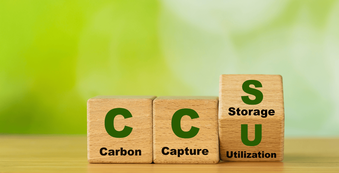 Wooden blocks displaying CCS acronym—Carbon, Capture, Storage, Utilization—on a green background.